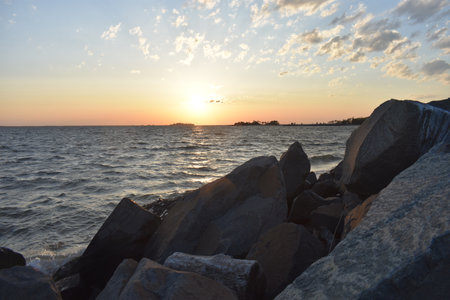 Large boulders line the shore at a Sandy Hook, New Jersey, bayside beach area at sunset -29の写真素材