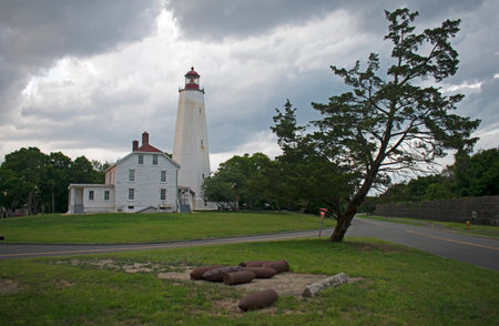 The threat of a downpour and stormy clouds engulf the Sandy Hook Lighthouse at Fort Hancock in Sandy Hook, New Jersey -90の写真素材