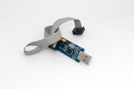 An AVR microcontroller downloader with USB port and connecting cable.