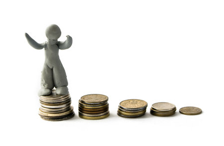 Plasticine figure and columns of coins