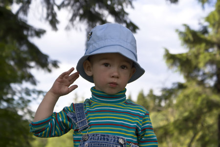 Portrait of the little boy on a summer wood backgroundの写真素材