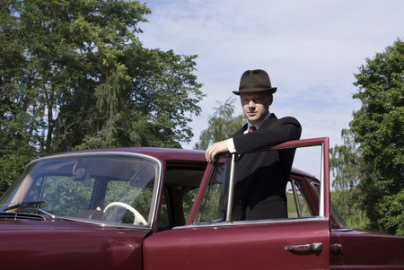 Old car driver on a door of the carの写真素材