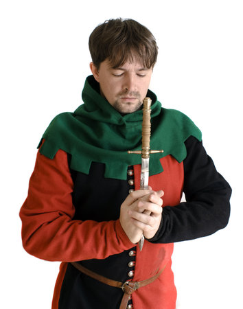 Medieval robber in black and red clothes prays with a knife in handsの写真素材