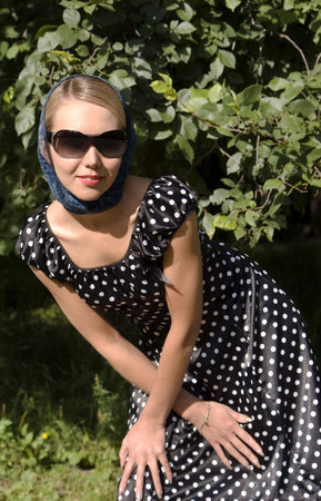 Beautiful girl in sunglasses on a foliage backgroundの写真素材