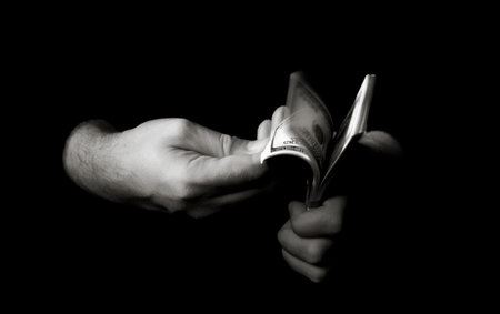 Hands with packs of dollars over blackの写真素材