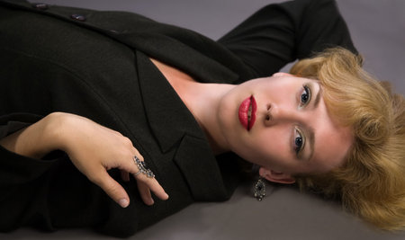 Beautiful blonde woman lying on the floorの写真素材