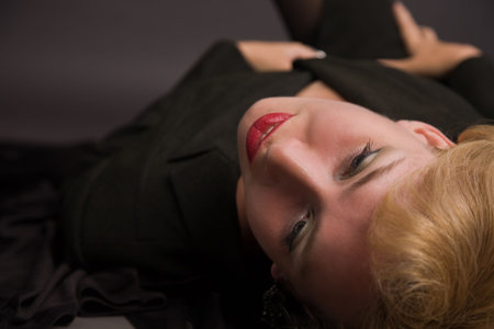 Beautiful blonde woman lying on the floorの写真素材