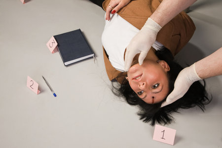 Forensic expert collecting evidence in a crime scene around a dead womanの写真素材