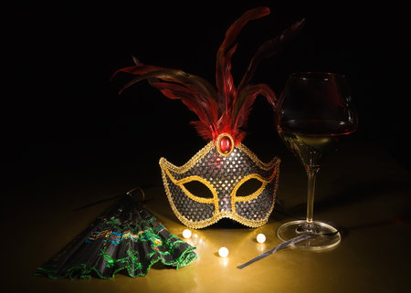 Accessories for the masquerade. Venetian mask, a glass of red wine, boa

の写真素材