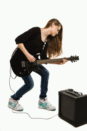 Teenager girl playing guitar against white background