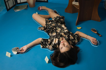 Poisoned brunette in a dressing gown lying on the floorの写真素材