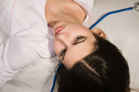 Lifeless young nurse lying on the sofaの写真素材