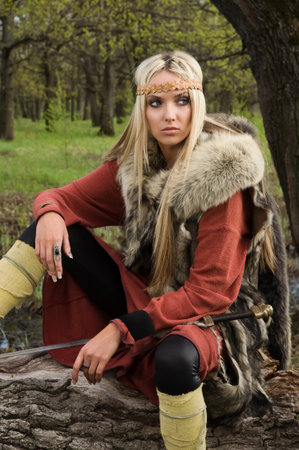 Viking girl warrior with sword in a woodの写真素材