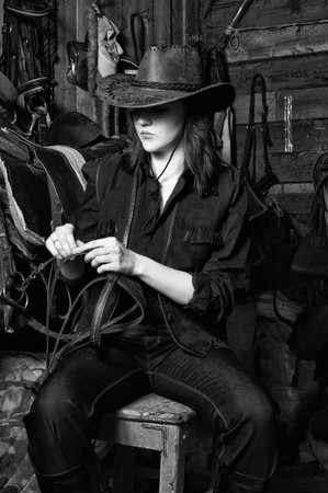 Young cowgirl in the stables at the ranchの写真素材