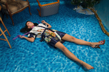 Crime scene simulation: strangled  brunette lying on the floorの写真素材