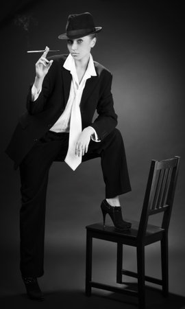 Vintage adult woman smoking cigarette over blackの写真素材