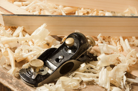 Black metal  wood planer on wooden plank の写真素材