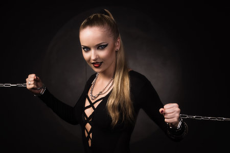 Beauty devil girl in a chains over full moon backgroundの写真素材