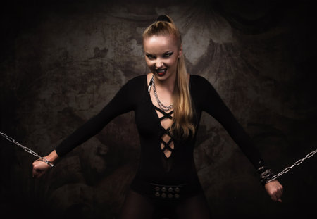 Portrait of a vampire girl in a silver chainsの写真素材