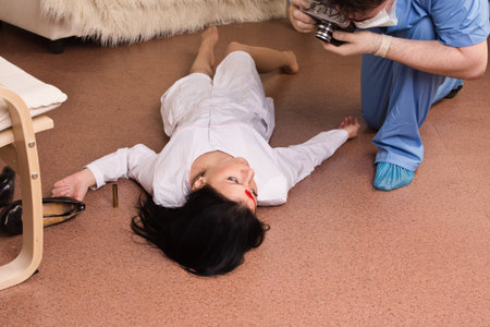 Forensic expert collecting evidence in a crime scene (imitation)の写真素材