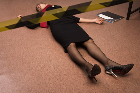 Crime scene imitation. Lifeless business woman lying on the floorの写真素材