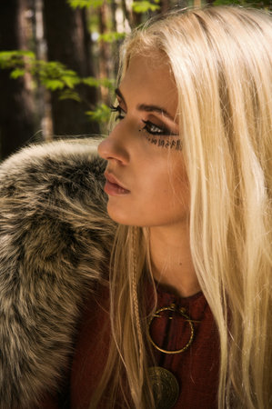Scandinavian girl with runic signs on a forest backgroundの写真素材