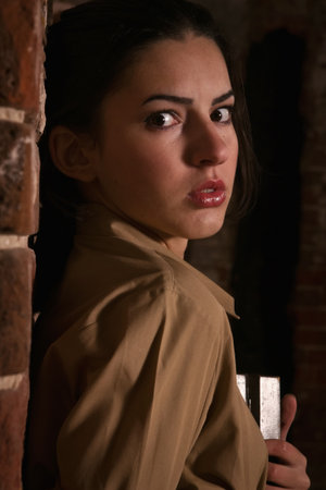 Frightened beautiful brunette hiding in the old ruinsの写真素材