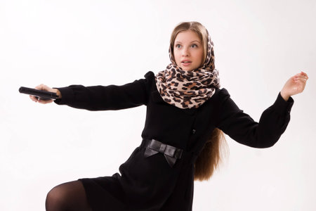 Spy girl in a black coat shoots a gunの写真素材