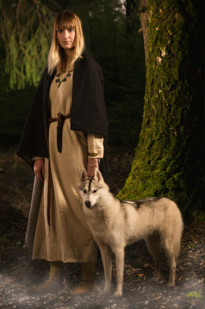 Slavonian girl in the traditional suit and siberian husky in the deep forest