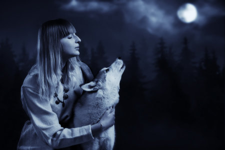 Slavonian girl in the traditional suit and gey wolf in the deep forestの写真素材