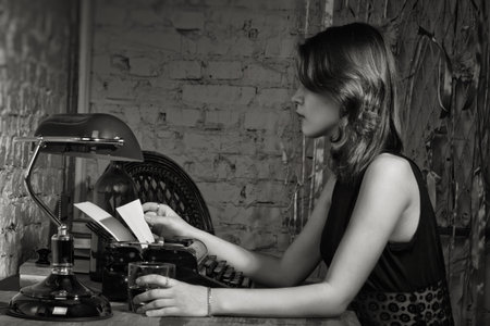 Elegant woman in black at the table with the old typewriter
の写真素材