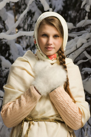 Russian beautiful girl in a traditional dress in the winter forestの写真素材