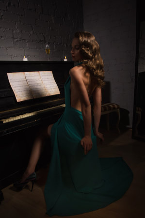 Pretty woman in evening dress playing pianoの写真素材