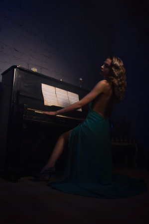 Pretty woman in evening dress playing pianoの写真素材