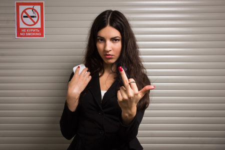 Business woman smokes against signs prohibiting smokingの写真素材