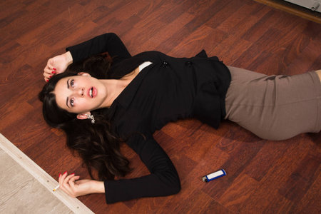 Crime scene in a office with lifeless businesswoman lying on the floorの写真素材
