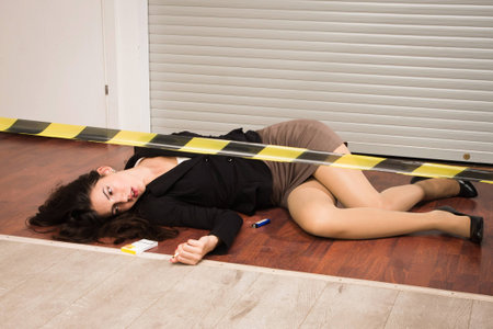 Crime scene in a office with lifeless businesswoman lying on the floorの写真素材