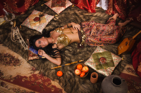 Beautiful belly dancer lying down in the arabic harem interiorの写真素材