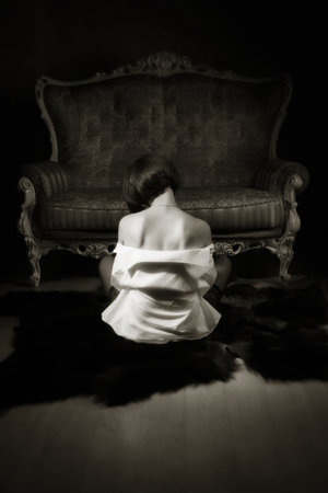 Attractive woman in sexy lingerie posing on a luxurious couchの写真素材