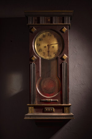 Old wooden grandfather clock hanging on a wall