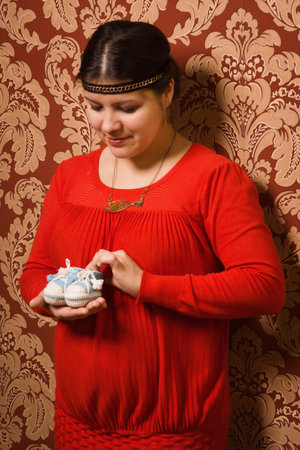Fashionable pregnant female posing in a luxury interior