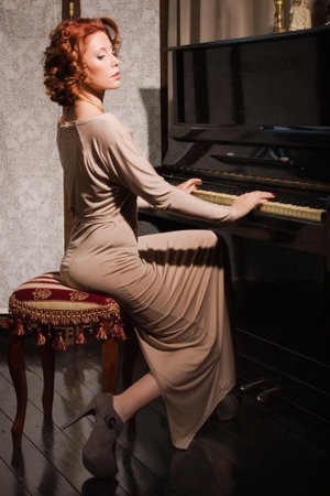 Pretty woman in evening dress playing pianoの写真素材
