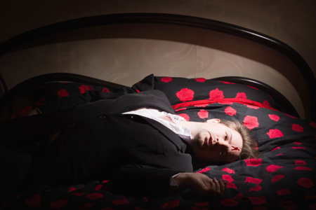 Corpse of business man lays on a bedの写真素材
