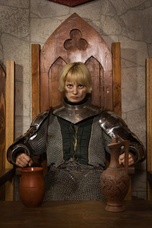 Joan of Arc. Girl in a knight's armor in the interior of a medieval castleの写真素材