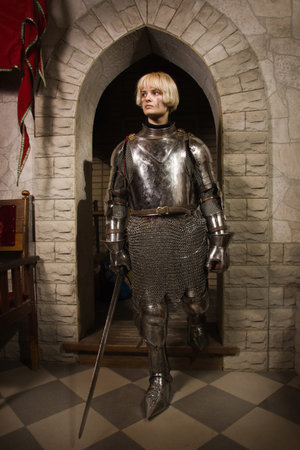 Joan of Arc. Girl in a knight's armor in the interior of a medieval castleの写真素材