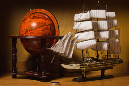 model sailing ship and old globe on a table