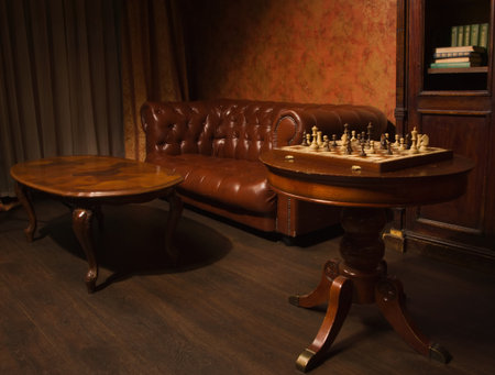 Classical library room with leather couch, wooden table