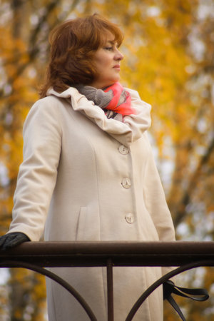 Beautiful elegant middle-aged woman in the autumn parkの写真素材