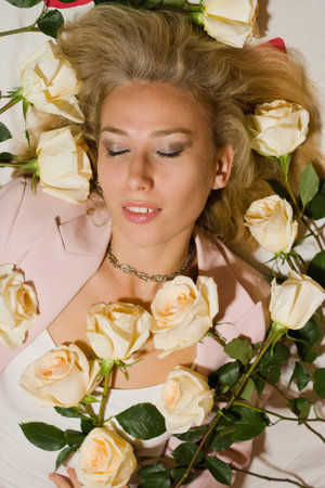 Beautiful woman with roses lying on the bedの写真素材