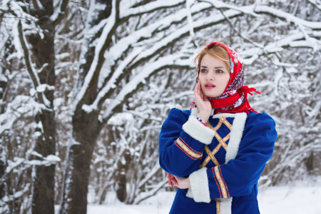 Russian beauty woman in traditional clothes against winter landscapeの写真素材